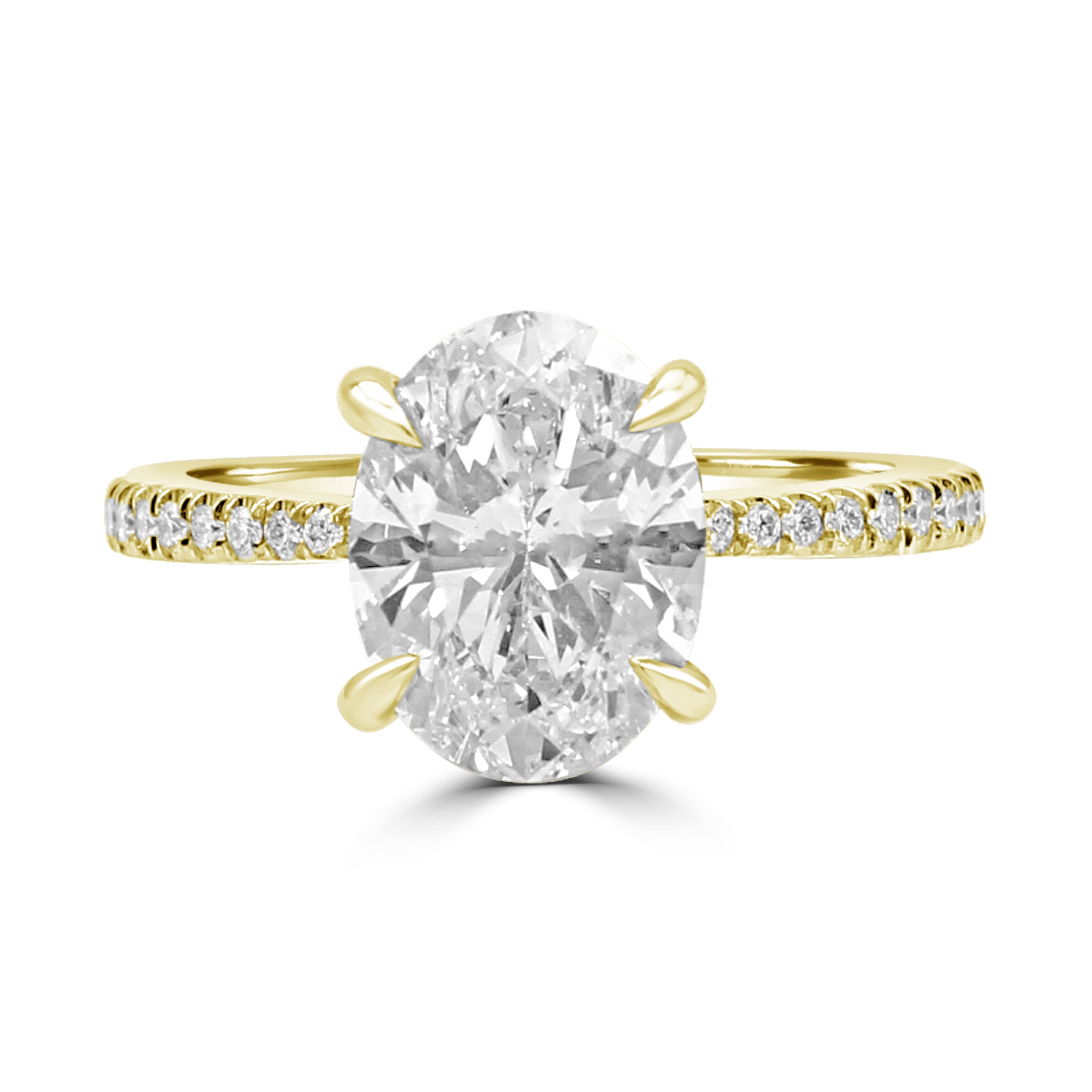Tapered Oval diamond engagement ring with pave diamonds on the band. Yellow gold.