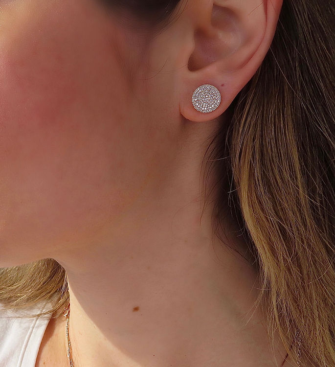 Diamonds all around this disc of gold earrings. On Model.