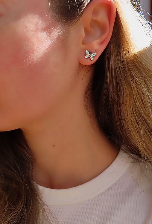 butterfly diamond earring shown worn by a woman
