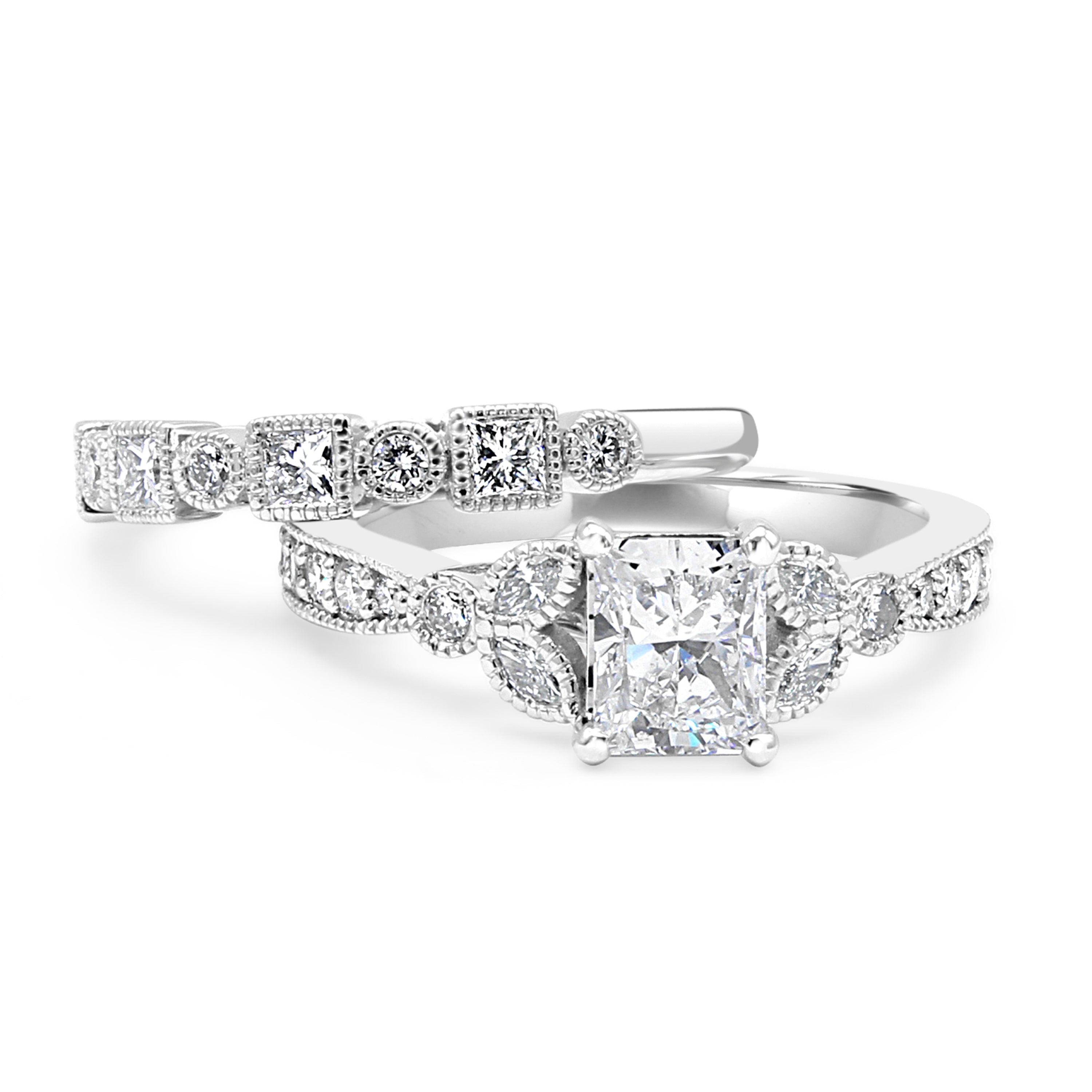 Radiant-cut center diamond surrounded by accent diamonds, featuring a millgrain detail on the shank.